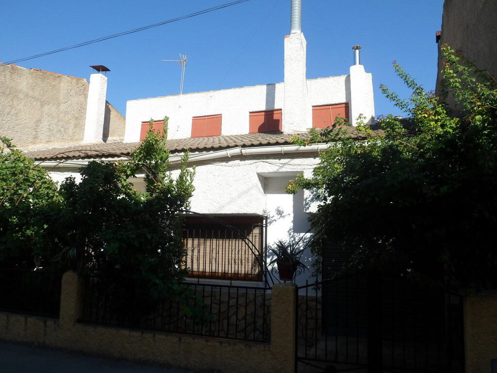 Village property in Zujar, Granada with traditional architecture and lush greenery.