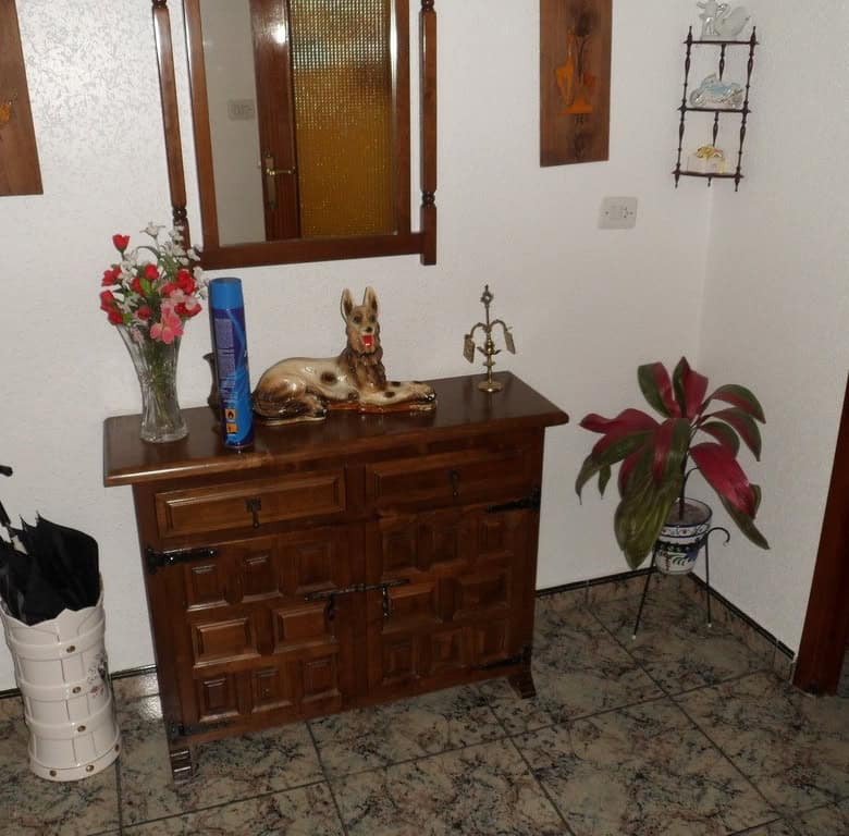 Cozy indoor space featuring wooden furniture, decorative items, and potted plants in a traditional v.