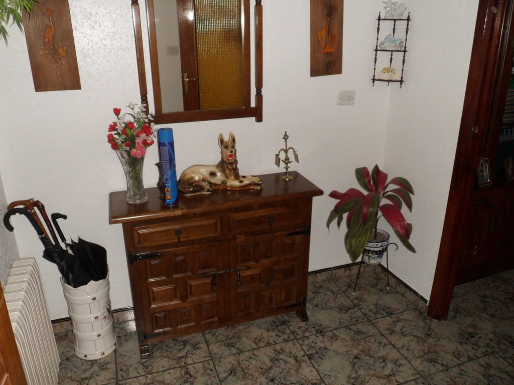 Cozy indoor space featuring wooden furniture, decorative items, and potted plants in a traditional v.