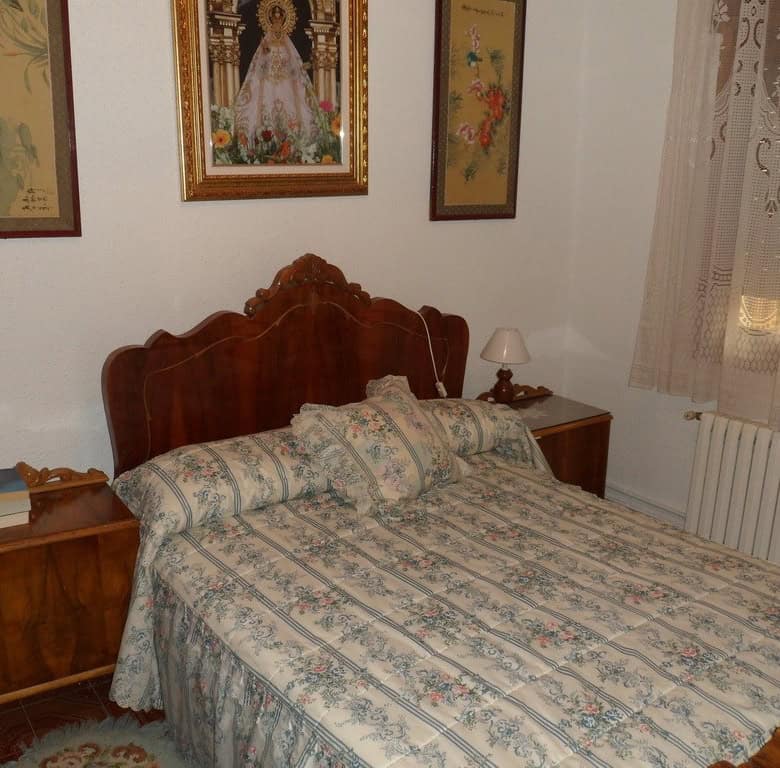 Cozy bedroom in a village property in Zujar, Granada, featuring traditional decor and wooden furnitu.