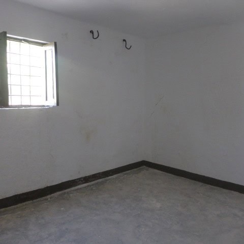 Interior of a rustic rural property in Castril, Granada, showing an unfinished room with a small win.
