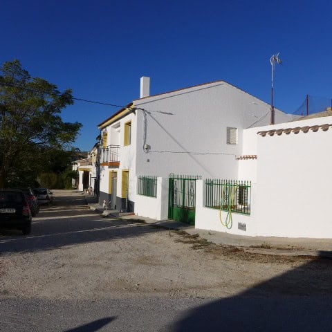 Cave house in Galera, Granada with white exterior walls and green window shutters.