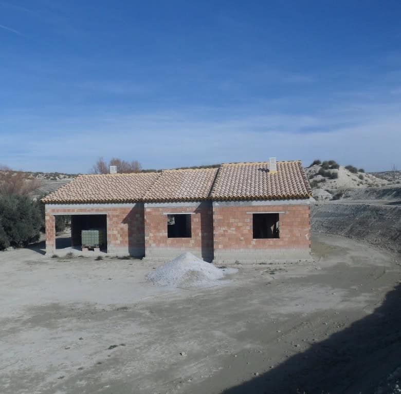 Farmhouse under construction in Benamaurel, Granada, with open land and scenic mountain views.