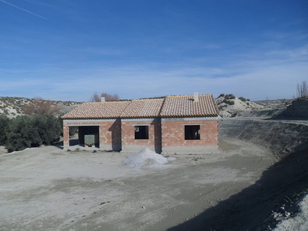 Farmhouse under construction in Benamaurel, Granada, with open land and scenic mountain views.