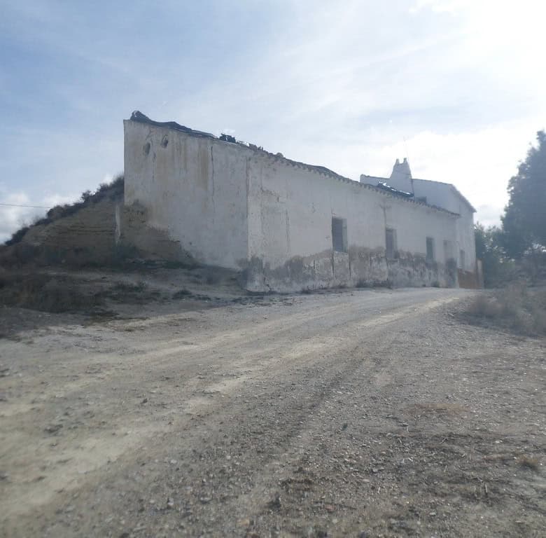 Cave house located in Baza, Granada, with rustic exterior and scenic surroundings.