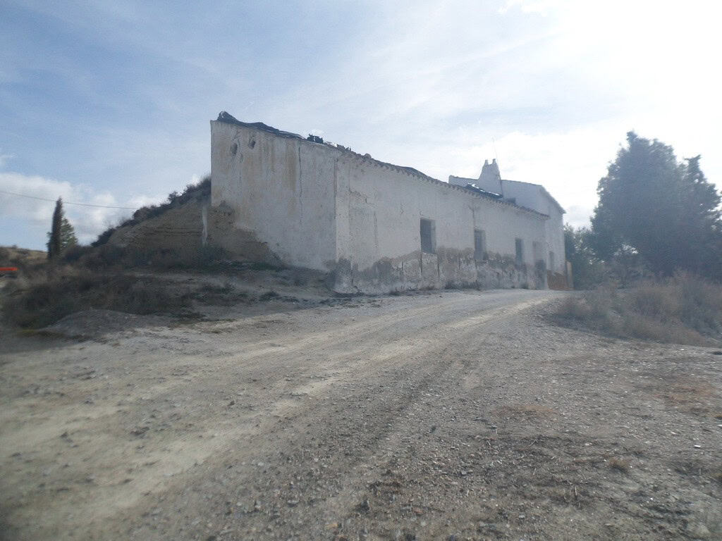 Cave house located in Baza, Granada, with rustic exterior and scenic surroundings.