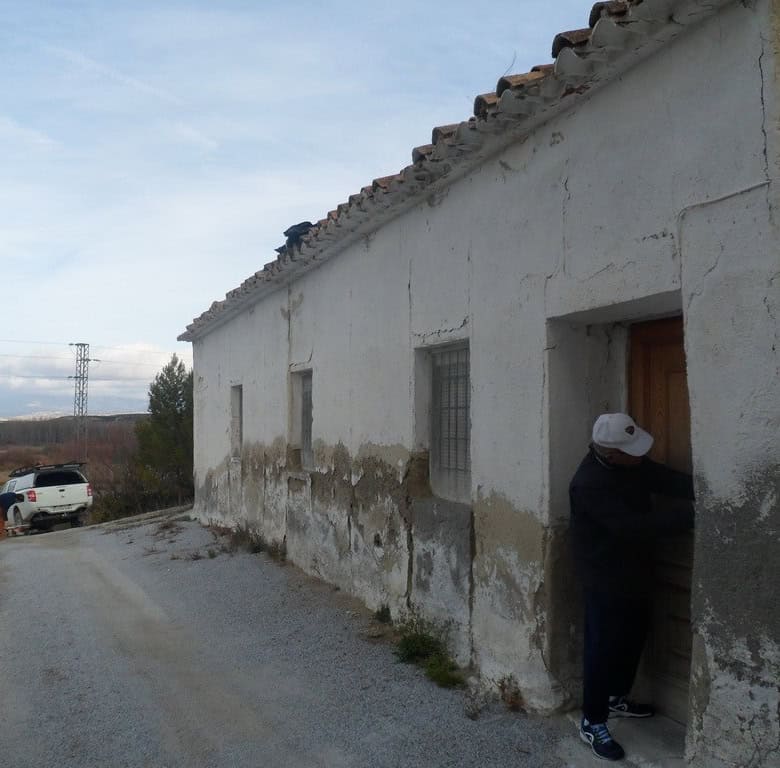 Traditional cave house in Baza, Granada with rustic exterior and rural surroundings.