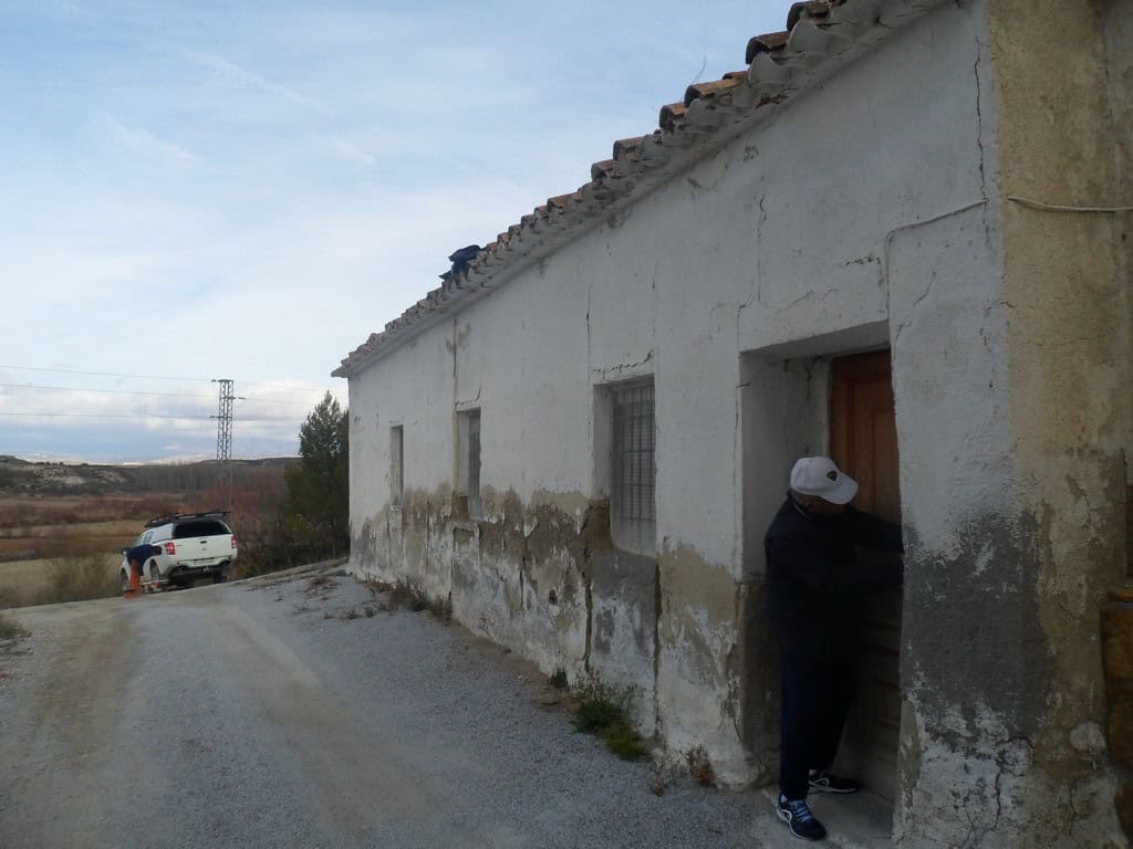 Traditional cave house in Baza, Granada with rustic exterior and rural surroundings.