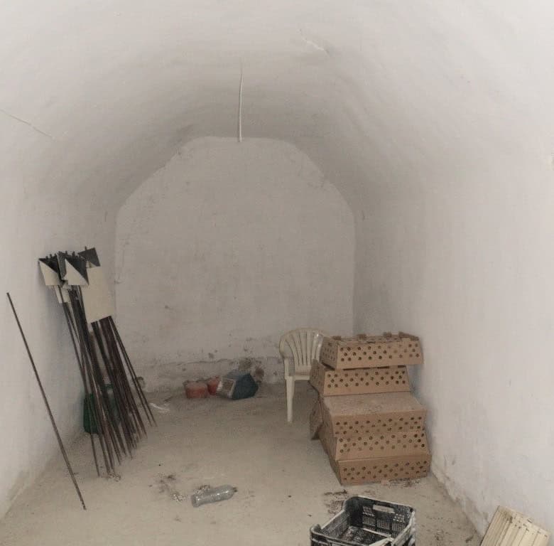 Cave house interior with white walls, simple furniture, and tools in Baza, Granada. Unique undergrou.