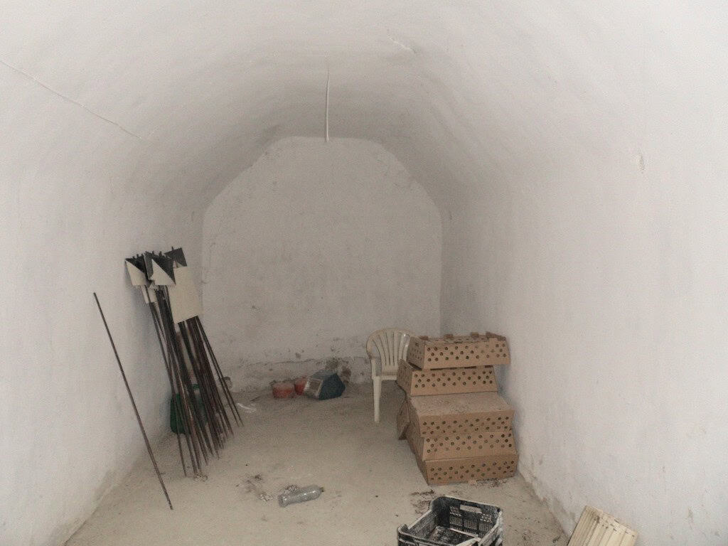 Cave house interior with white walls, simple furniture, and tools in Baza, Granada. Unique undergrou.