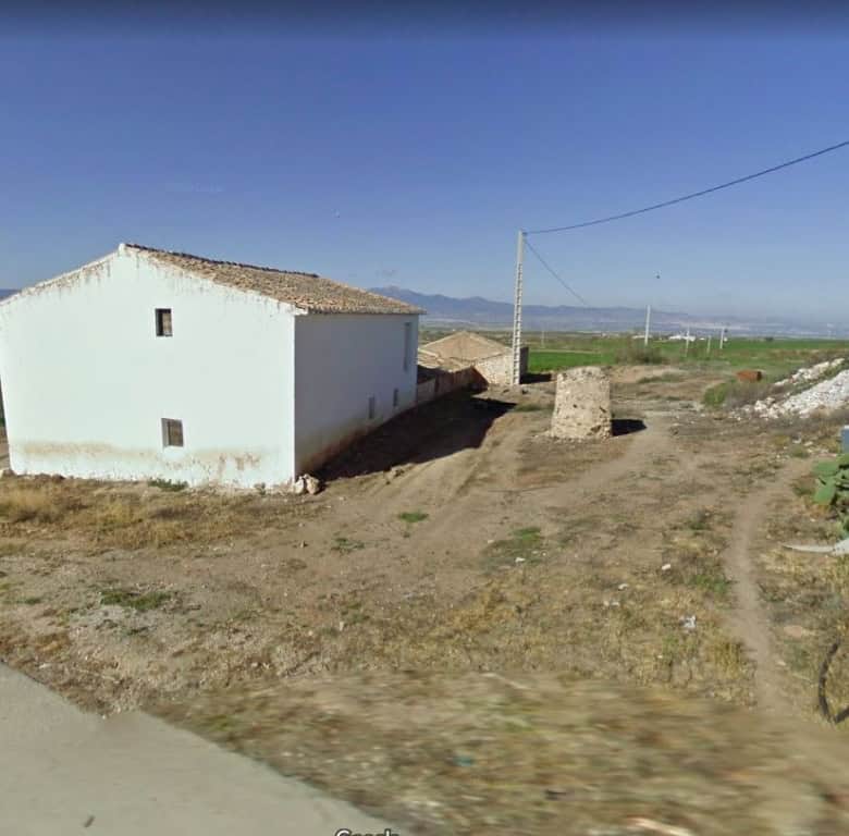 Rural property in Baza, Granada with traditional white exterior and surrounding open landscape. Idea.