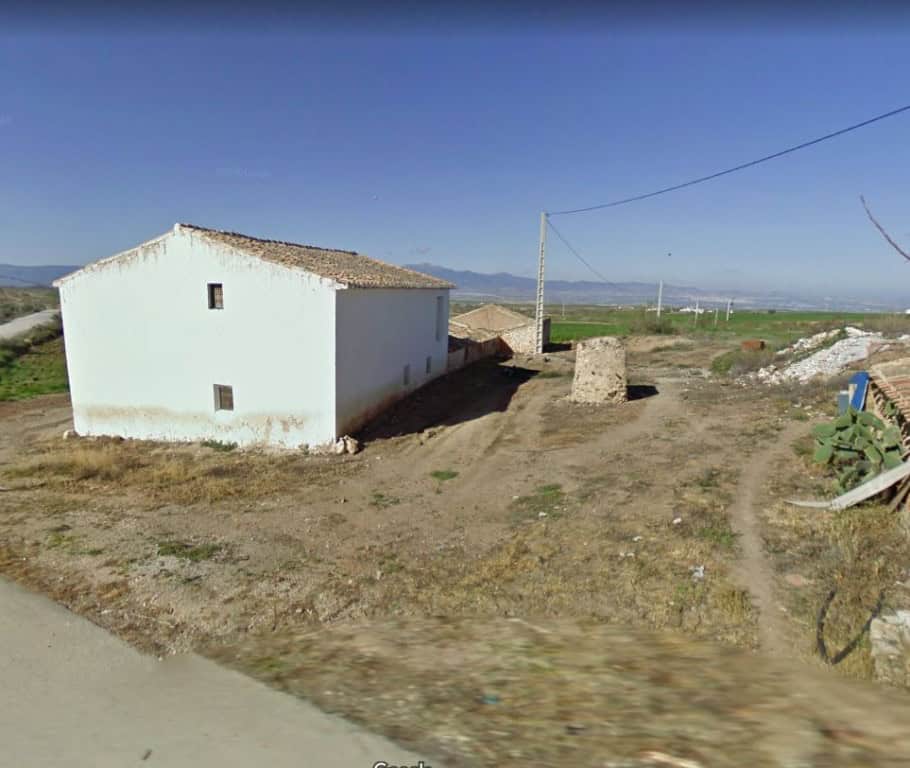 Rural property in Baza, Granada with traditional white exterior and surrounding open landscape. Idea.