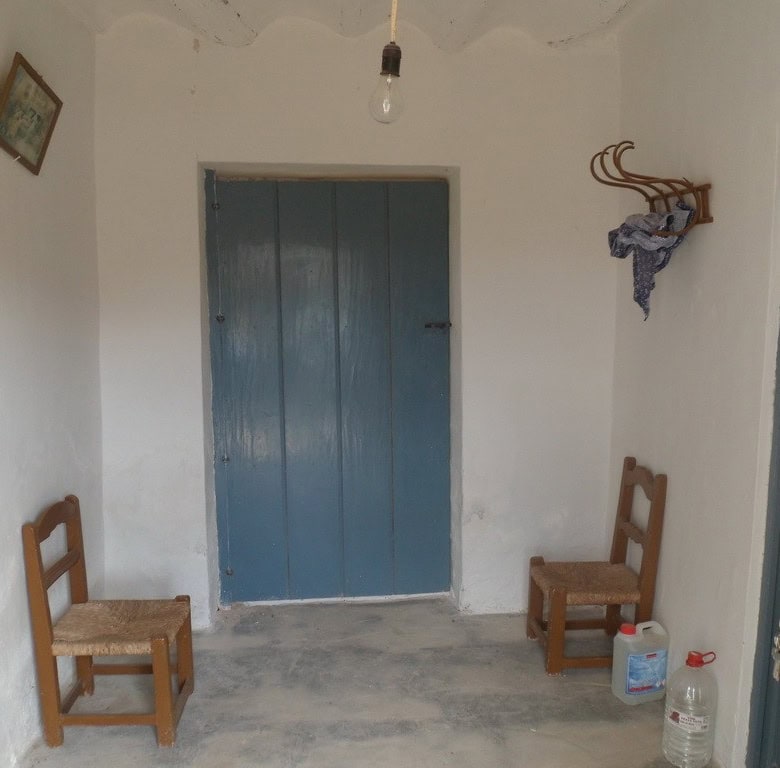 Rural property in Baza with traditional interior, wooden chairs, and simple decor in Granada, Spain.