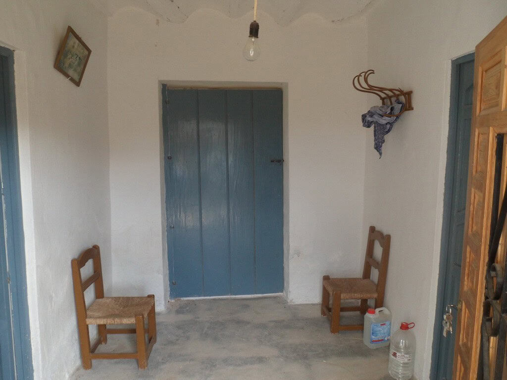 Rural property in Baza with traditional interior, wooden chairs, and simple decor in Granada, Spain.