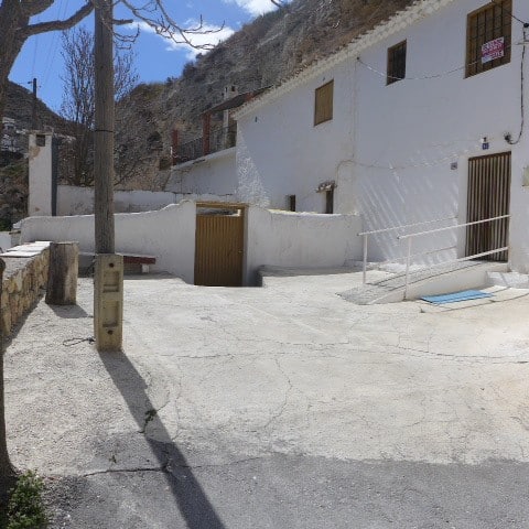 Cave house in Galera, Granada with white exterior walls and mountain backdrop.