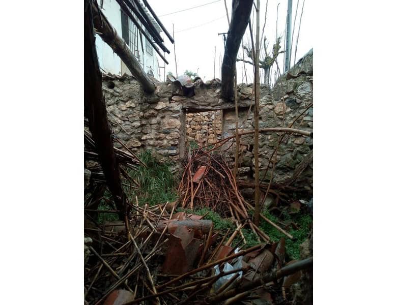 Ancient ruin in Oria, Almeria with fallen stones and overgrown vegetation.