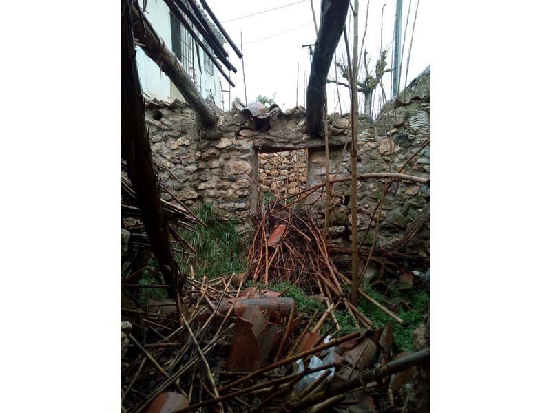 Ancient ruin in Oria, Almeria with fallen stones and overgrown vegetation.