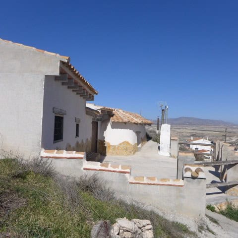 Traditional cave house with whitewashed walls and terracotta roof tiles in Orce, Granada.