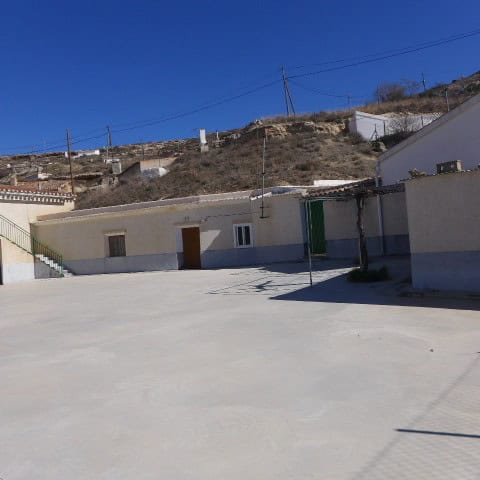 Cave house in Orce, Granada with white exterior walls and mountain backdrop.