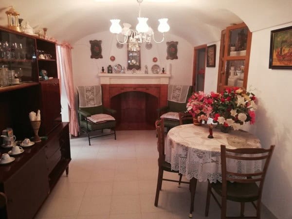 Charming interior of a cave house in Orce, Granada, featuring a fireplace, vintage furniture, and de.