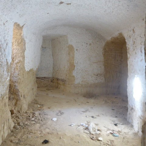 Historic cave house interior in Huescar, Granada, showcasing traditional stone walls and arched ceil.