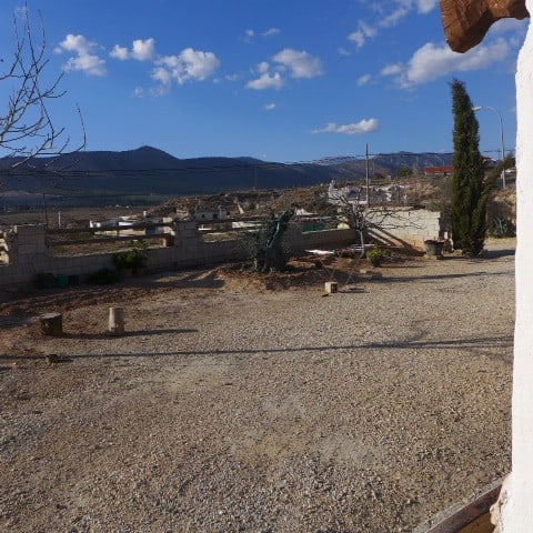 Cave house in Huescar, Granada with mountain views and rustic outdoor space.