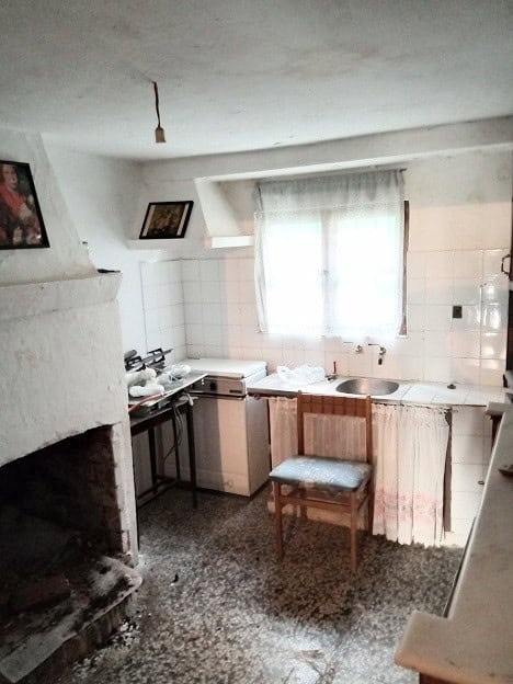Charming kitchen of a town house in Gor, Granada, featuring a small window, basic appliances, and ru.