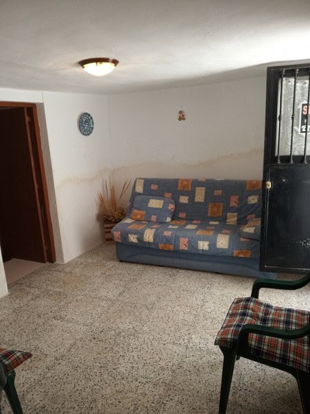 Cozy village property interior in Gor, Granada with simple furnishings and a small living area.
