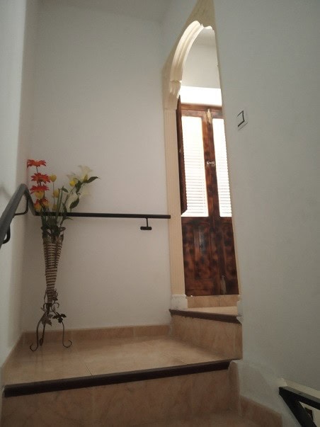 Charming village property entrance in Gor, Granada with wooden door and decorative flowers.