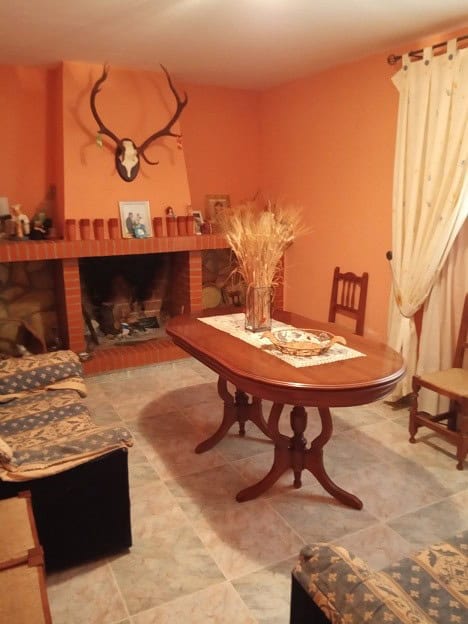 Cozy interior of rural property in Gor, Granada with warm decor and traditional fireplace.
