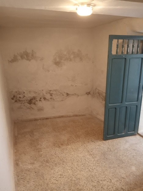 Village property interior with water damage and peeling walls in Gor, Granada.