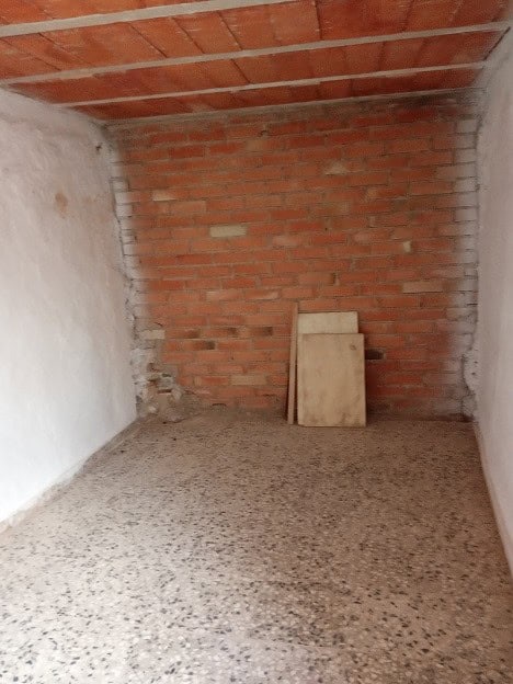 Interior of a rustic village property in Gor, Granada, showing unfinished brick walls and a tiled ce.