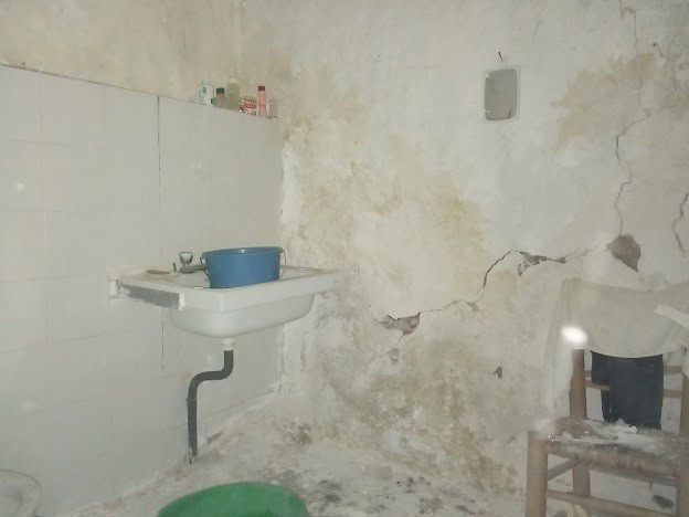 Old rustic kitchen in Belerda, Jaen with worn walls and basic fixtures.