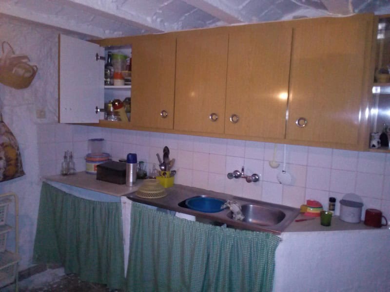 Village property kitchen with basic amenities in Urracal, Almeria, featuring wooden cabinets and a s.