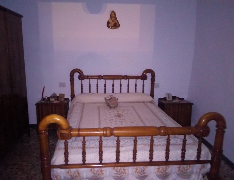 Charming village property in Urracal, Almeria, featuring a cozy bedroom with traditional wooden bed.