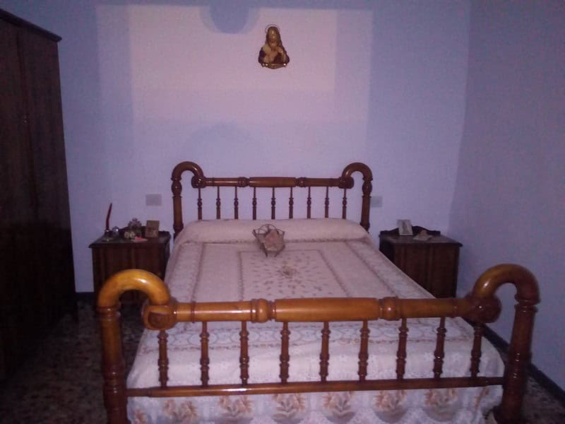 Charming village property in Urracal, Almeria, featuring a cozy bedroom with traditional wooden bed.