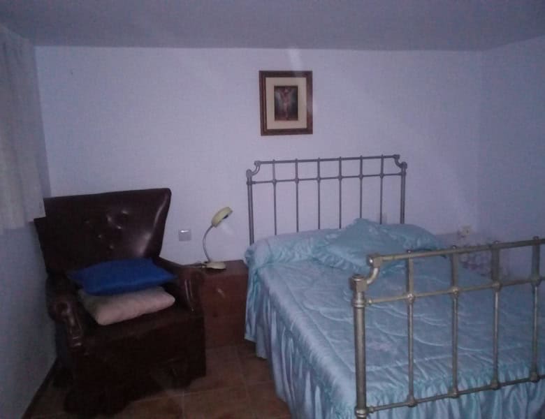 Charming bedroom in a village property in Urracal, Almeria, featuring a metal bed frame and cozy dec.