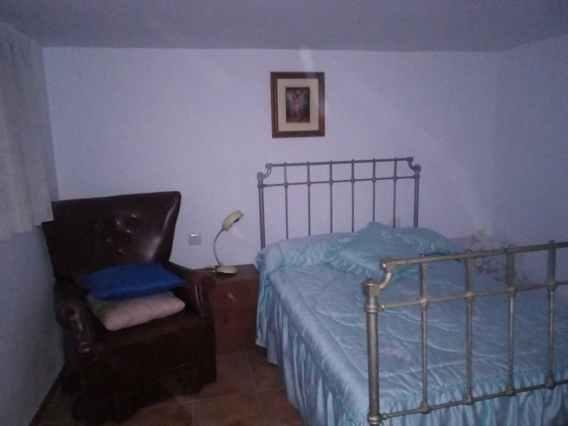 Charming bedroom in a village property in Urracal, Almeria, featuring a metal bed frame and cozy dec.