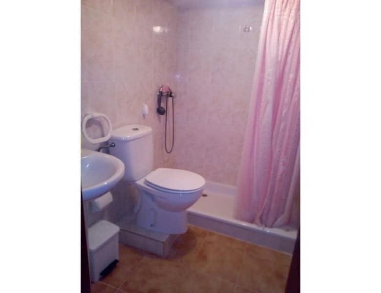 Cozy village bathroom with toilet, sink, and shower in Urracal, Almeria.