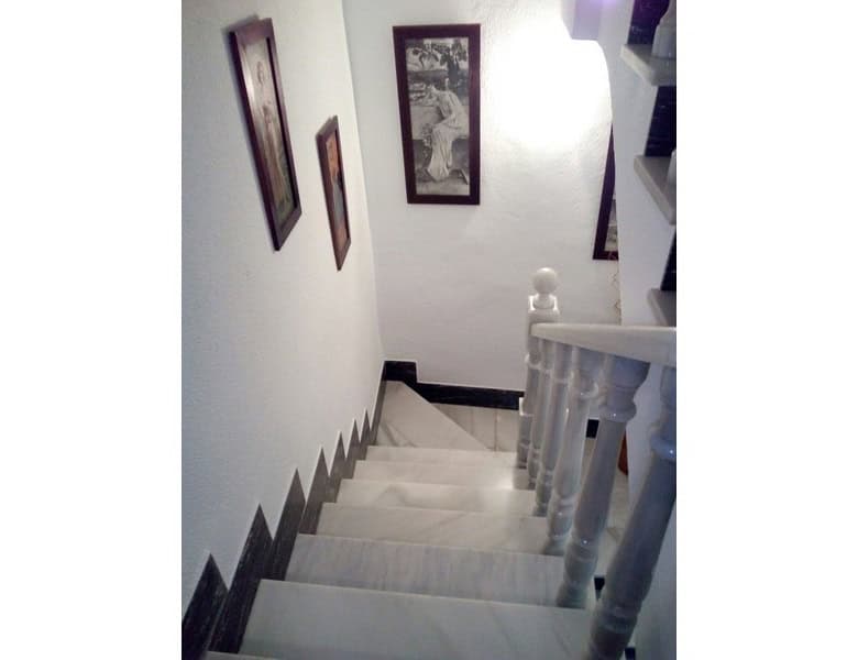 Charming village property staircase in Somontin, Almeria with white walls and decorative framed artw.