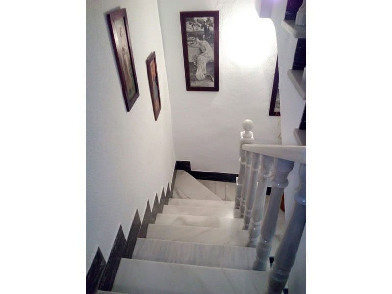 Charming village property staircase in Somontin, Almeria with white walls and decorative framed artw.