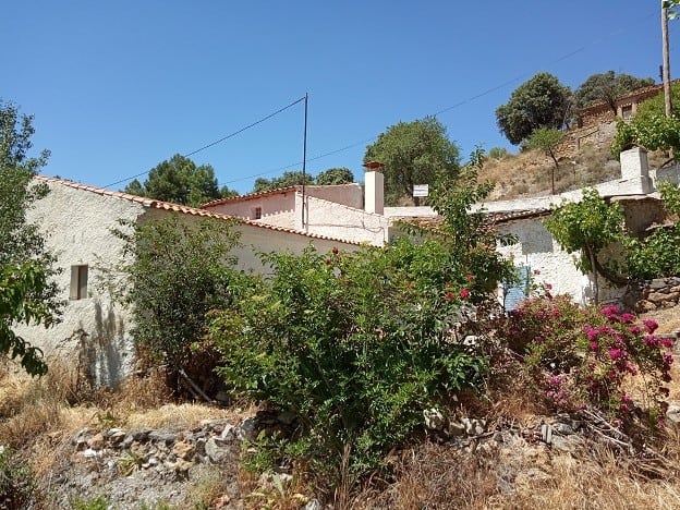 Rural property in Gor, Granada with traditional whitewashed buildings and lush greenery.