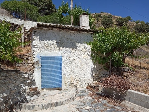 Rural property in Gor, Granada with traditional stone walls and scenic mountain views.
