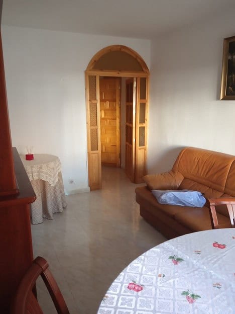 Apartment in Gor, Granada with traditional wooden door and simple living room decor.