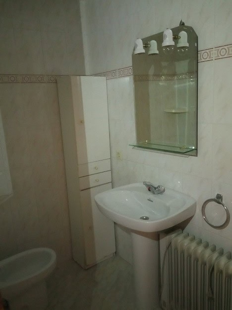 Cozy bathroom in an apartment in Gor, Granada, featuring a sink, mirror, and radiator.