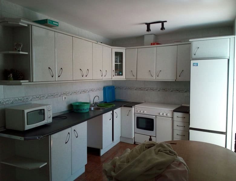 Charming village property in Armuna, Almeria, featuring a modern kitchen with white cabinets and ess.