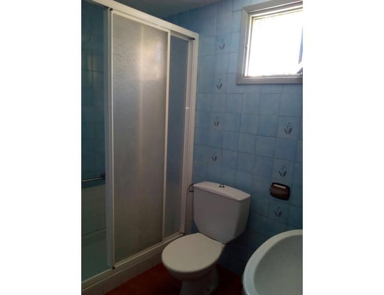 Cozy bathroom with shower, toilet, and small window in Armuna village property.