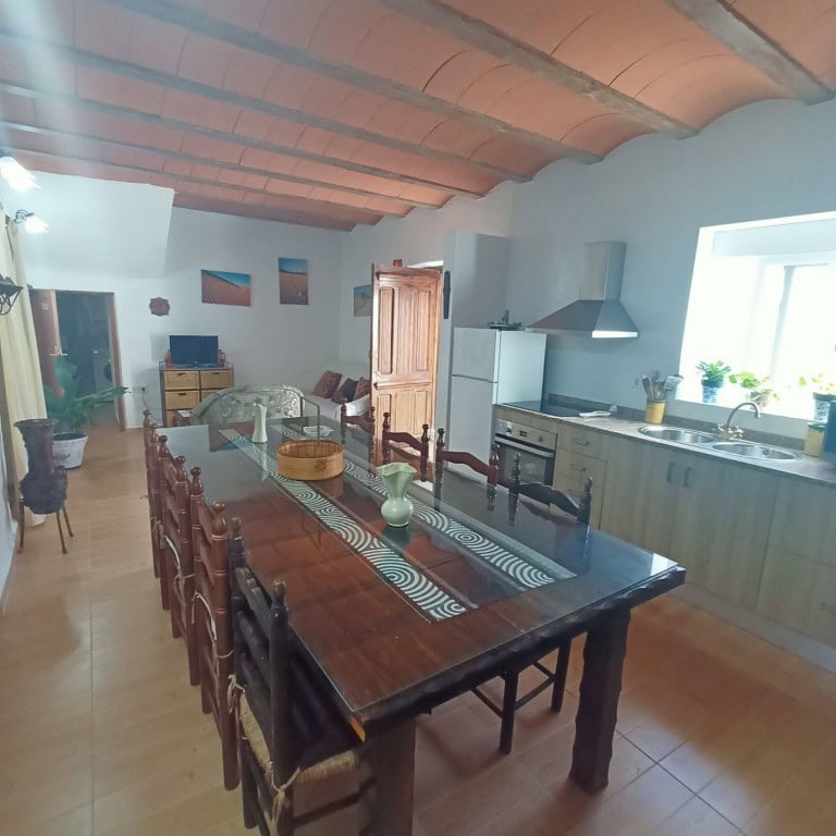 Charming interior of a cave house in Fontanar, Jaen, showcasing rustic wooden ceiling and cozy livin.