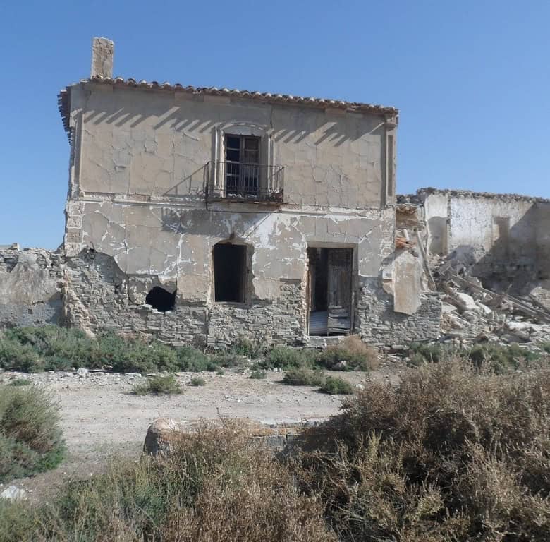 Abandoned stone house with weathered walls and rustic charm in Venta del Peral, Granada.