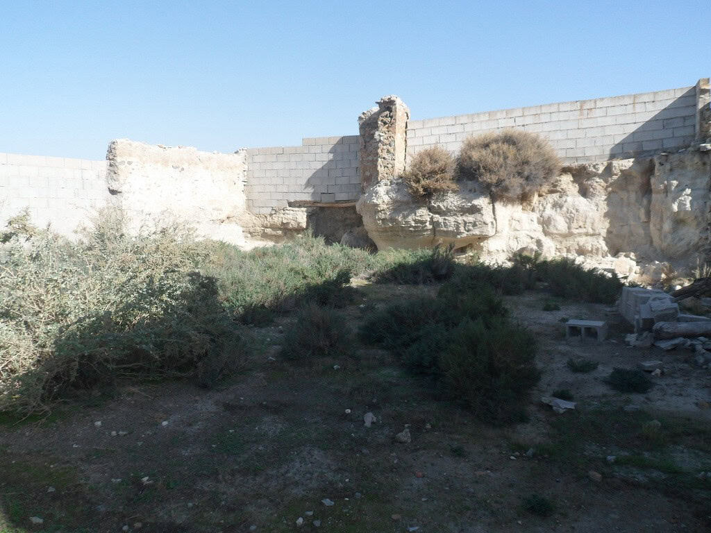 Empty rural land with stone walls and sparse vegetation in Venta del Peral, Granada.